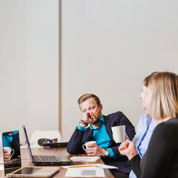 Free photo people sitting at desk in office smiling