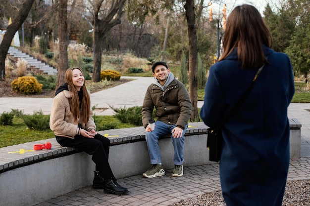 Free photo people sitting at distance on bench