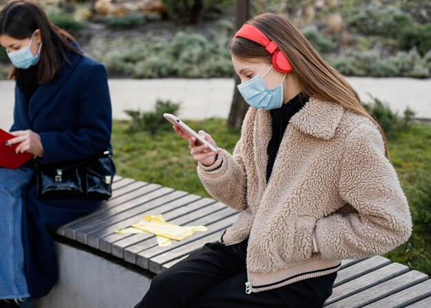 Persone sedute a distanza e con indosso una maschera