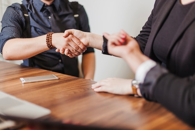 People sitting at table shaking hands