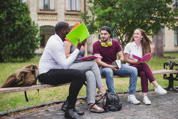 Free photo people sitting on wooden bench outside