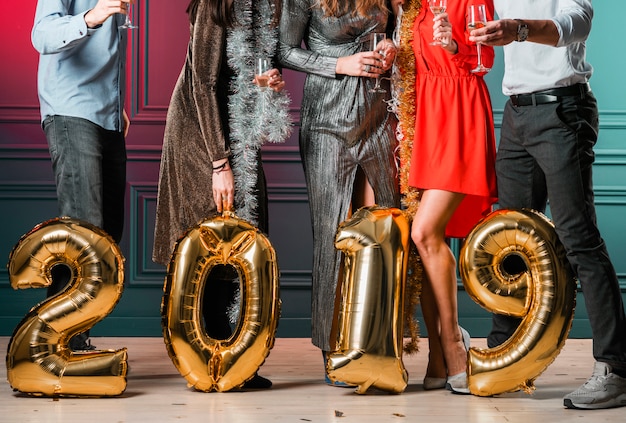 Free photo people standing with 2019 inscription from balloons