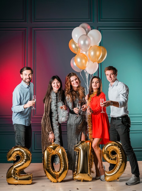 People standing with 2019 inscription from gold balloons