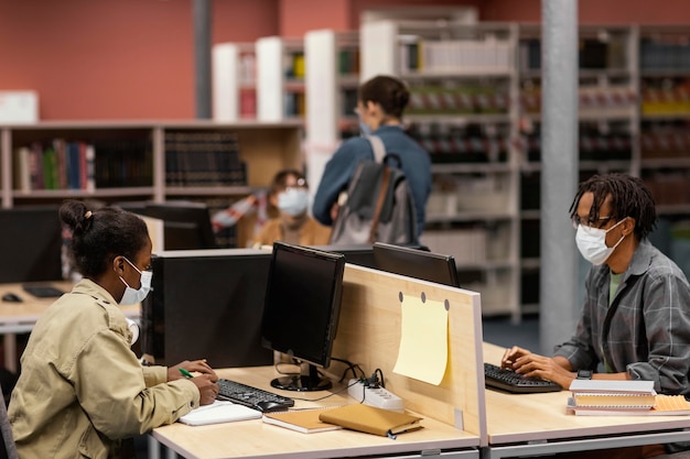 Foto gratuita persone che studiano pacificamente in biblioteca