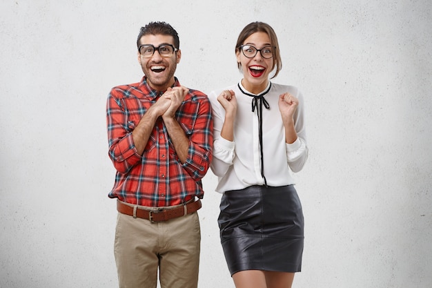 Persone, successo, concetto di felicità. bella donna e uomo barbuto goffo guardano con gioia,