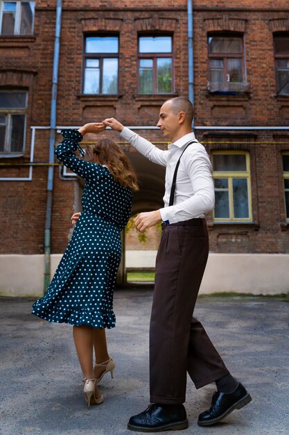 People swing dancing outdoors full shot