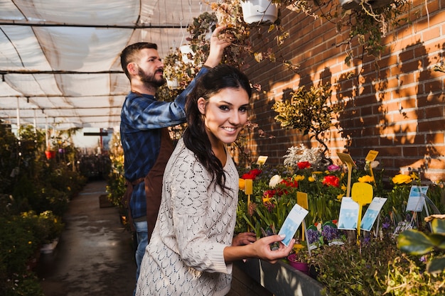 People taking care of flowers in greenhouse