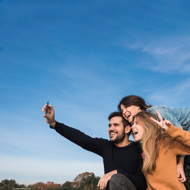 People taking selfie on blue sky background 