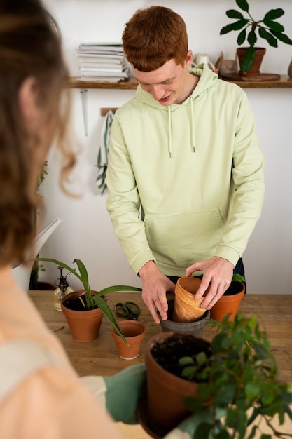 新しい鉢に植物を移植する人々