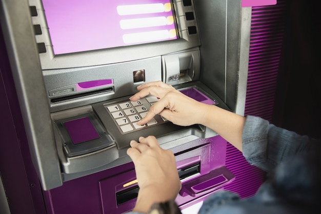 People waiting to get money from automated teller machine - people withdrawn money from ATM concept