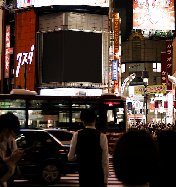 People waiting for light to turn so they can cross the street in the city