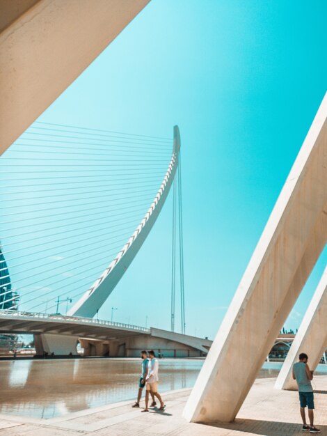 People walking next to modern bridge