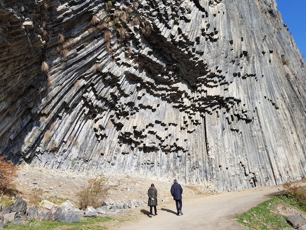 Foto gratuita persone che camminano attraverso un sentiero nella gola di garni sotto la luce del sole in armenia