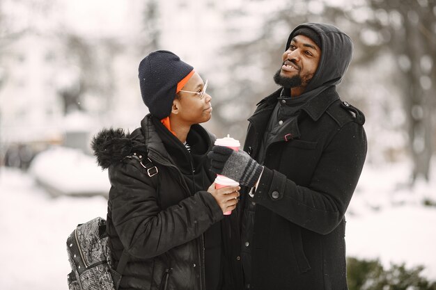 People walks outside. Winter day. African couple.