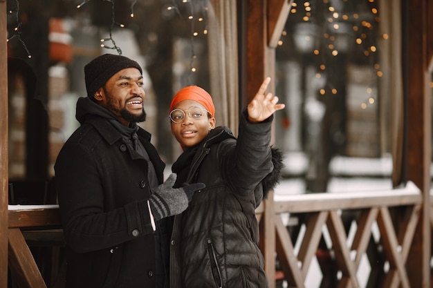 People walks outside. Winter day. African couple.