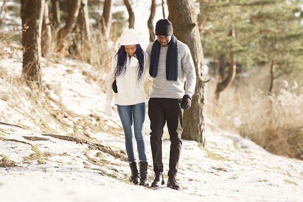 People walks outside. Winter day. African couple