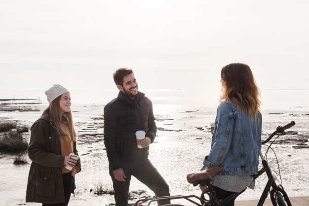 People in warm clothes talking on seashore