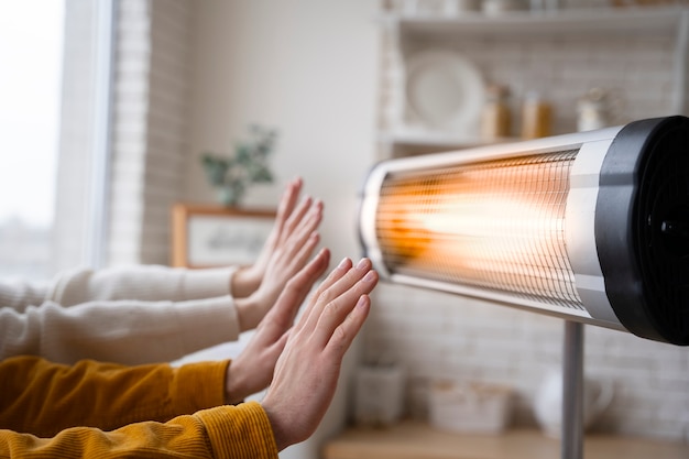 People warming up hands near heater
