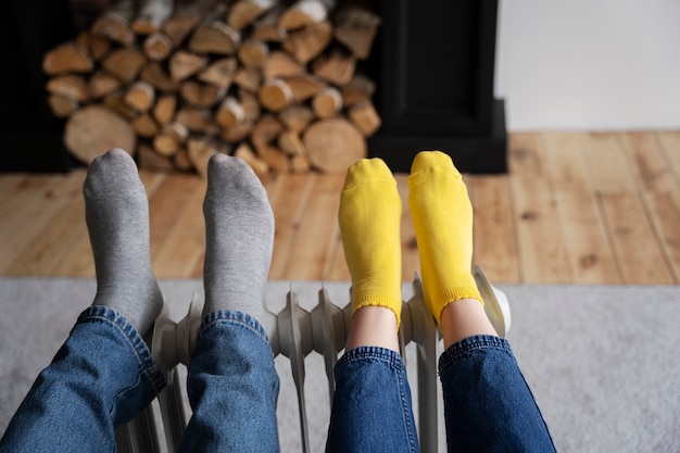 Free photo people warming up their feet on heater