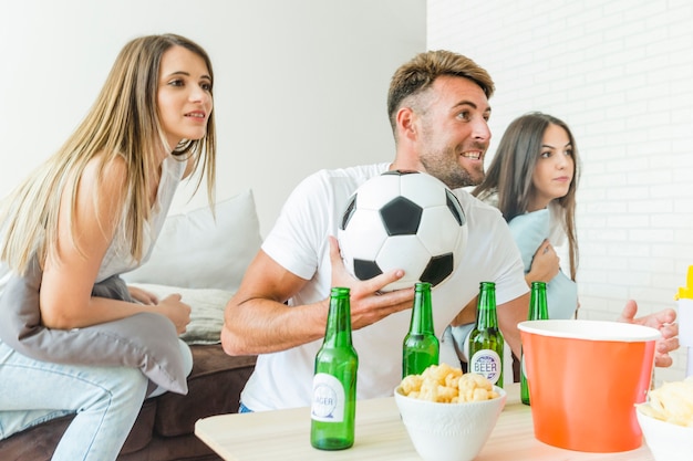 People watching football home with beers 