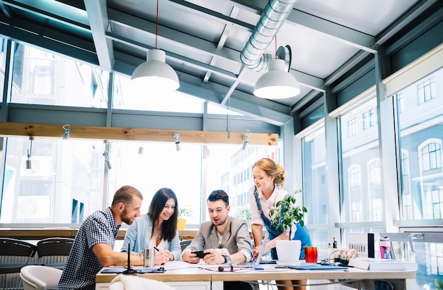 Foto gratuita persone che guardano telefono in ufficio