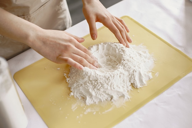 People while preparing dumplings. Asian people in aprons.