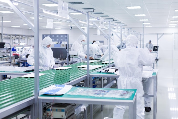 People in white isolating costumes working in laboratory