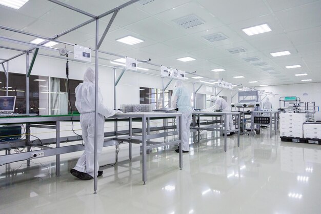 People in white isolating costumes working in laboratory