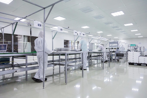 People in white isolating costumes working in laboratory