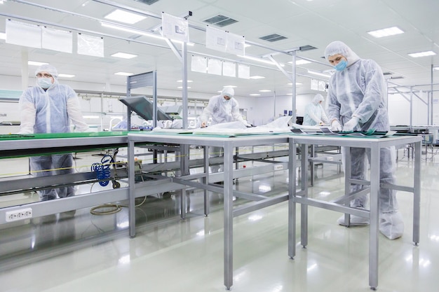 People in white isolating costumes working in laboratory