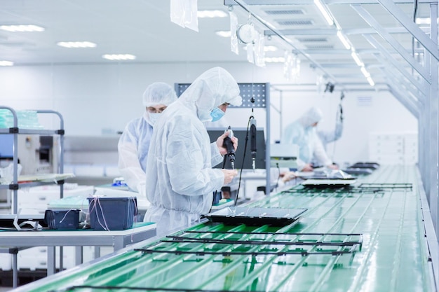 People in white isolating costumes working in laboratory