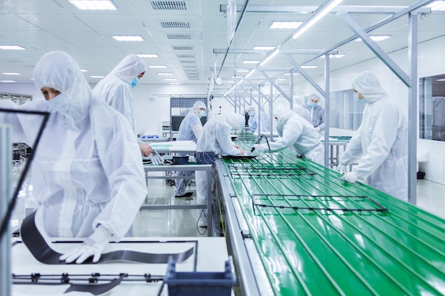 People in white isolating costumes working in laboratory