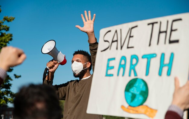 Foto gratuita persone con maschera alla protesta ambientale