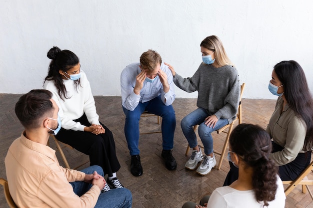 People with medical masks in group therapy session