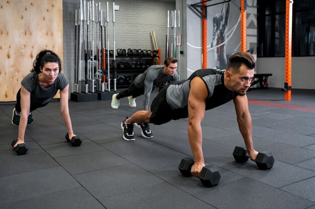 People working out indoors together with dumbbells