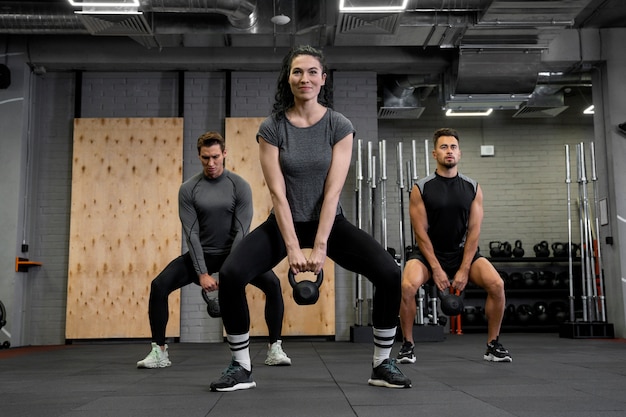 Free photo people working out indoors together with dumbbells