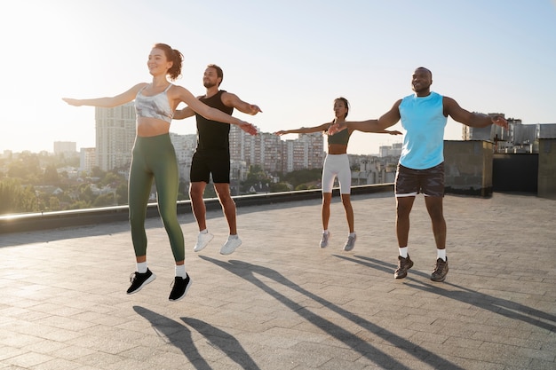 Free photo people working out together at sunset outdoors