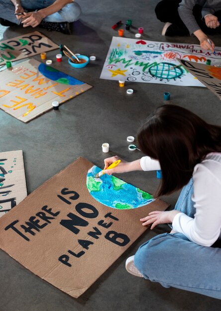 People writing and drawing protest banners