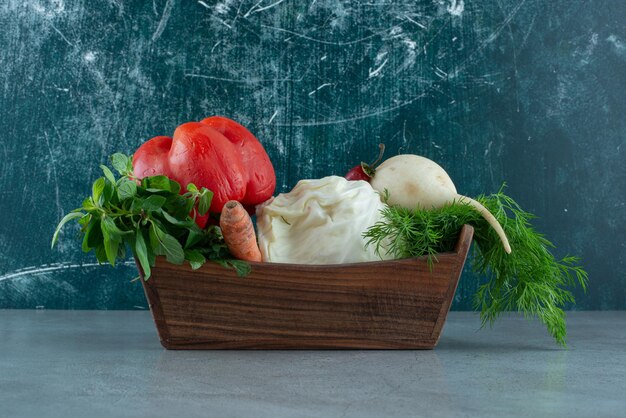 Pepper, white radish and greens in wooden box.