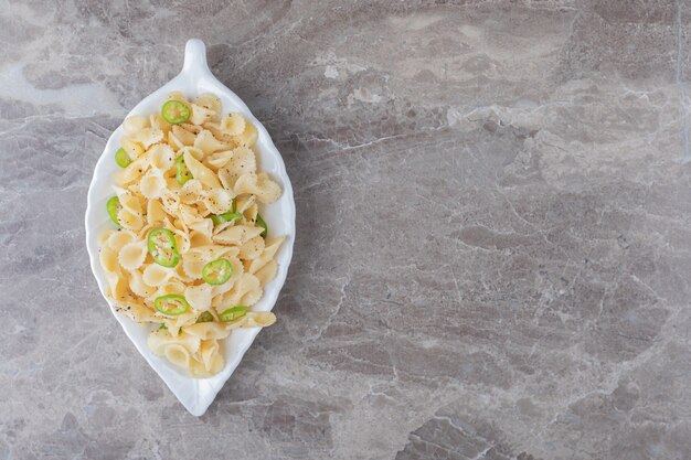 Peppered farfalle pasta on a fancy plate , on the marble surface.