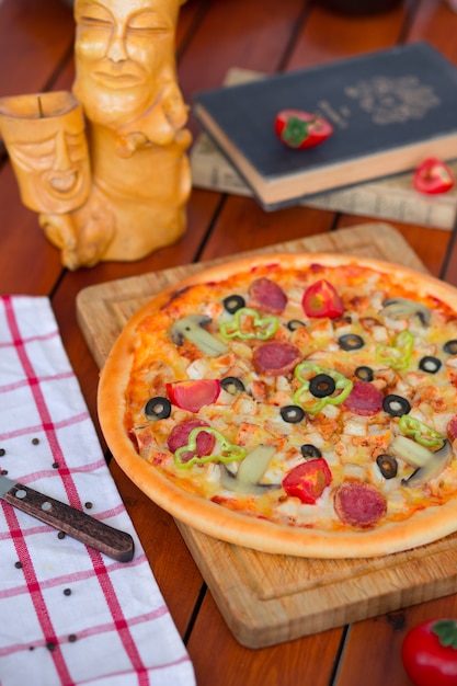 Pepperoni pizza with bell pepper, tomato slices, mushroom and olives   