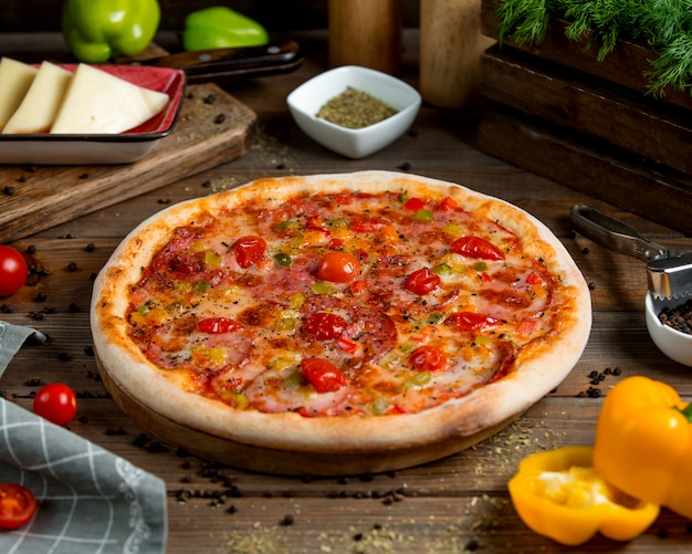 Pepperoni pizza with tomato bell peppers herbs and cheese