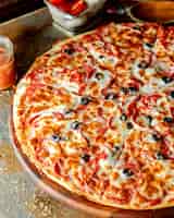 Free photo pepperoni pizza with tomato and olive