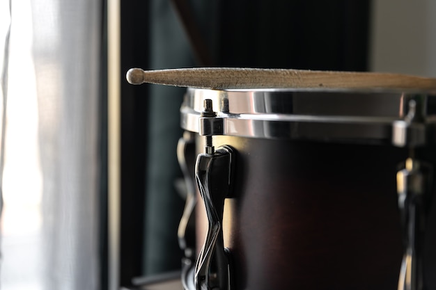 Free photo percussion instrument, snare drum with sticks close up in the room interior.