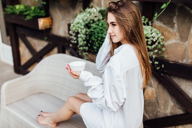 Foto gratuita mattinata perfetta. bella donna in hotel con una tazza di drink, rilassante presto.