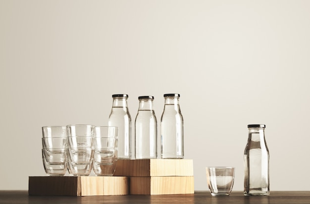 木製で提示された透明なガラス瓶とカップの純粋なきれいな健康的な水の完璧なセット