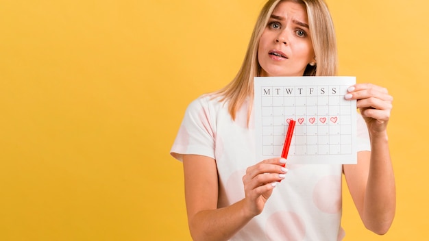 Period calendar with drawn heart shapes and woman