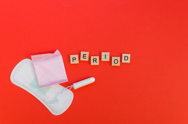 Period word with scrabble letters and pads and tampon