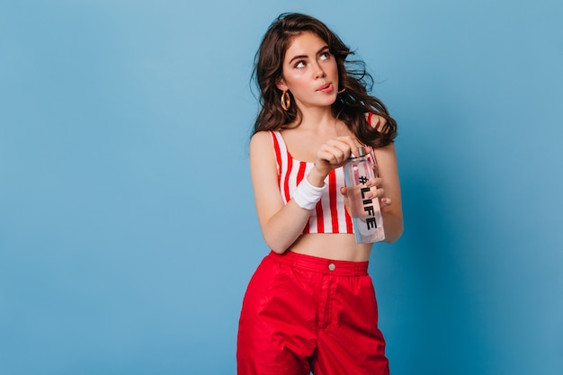 Perky pink-cheeked woman opens bottle of water