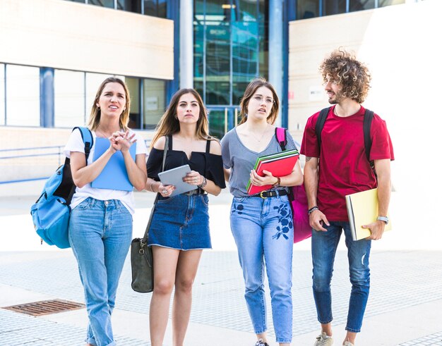 Perplexed students standing near university building